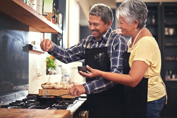 husband and wife cooking at kitchen stove